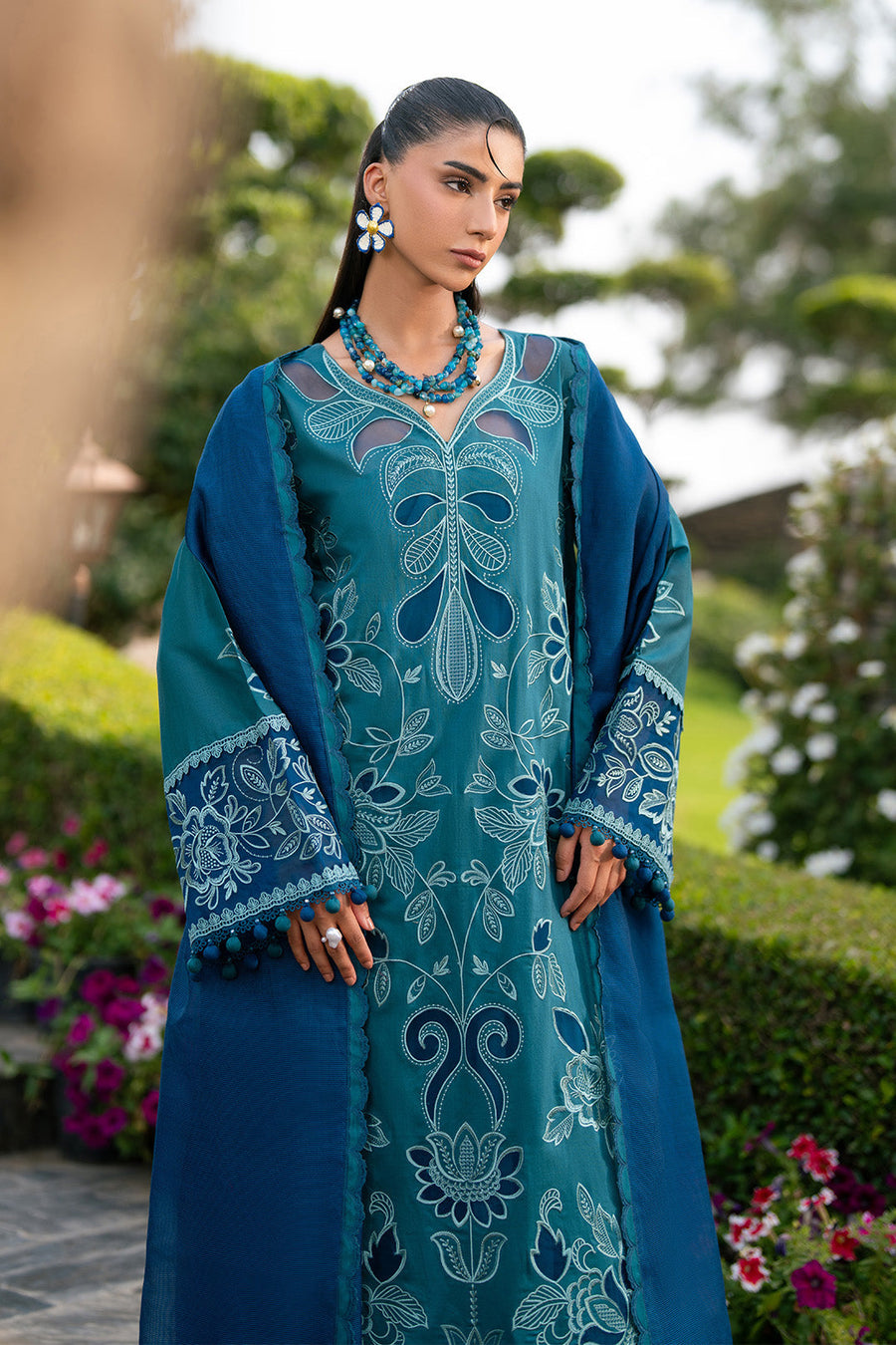 Woman posing with the blue dupatta draped around shoulders highlighting fabric texture and embroidered borders