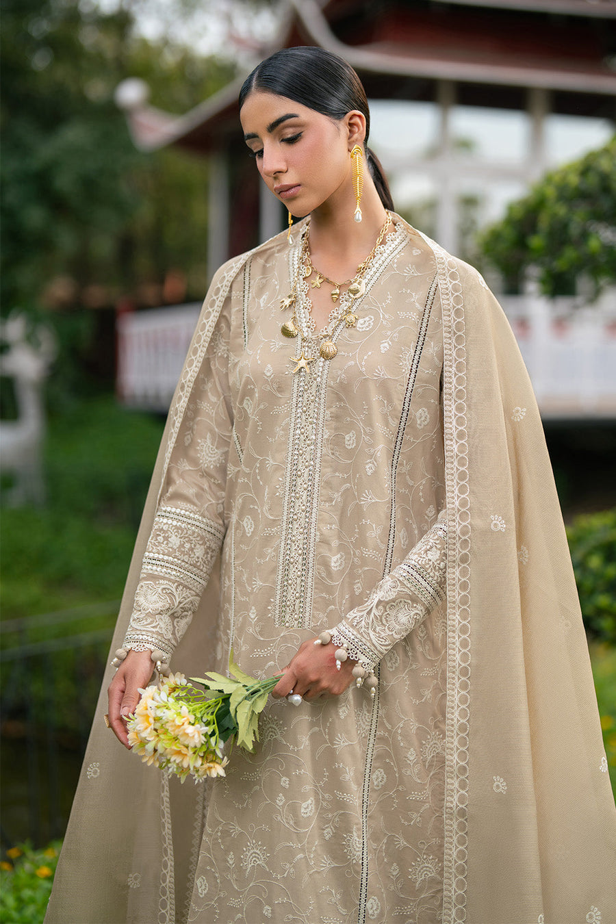 Model showcasing embroidery detail on sleeves holding flower bouquet