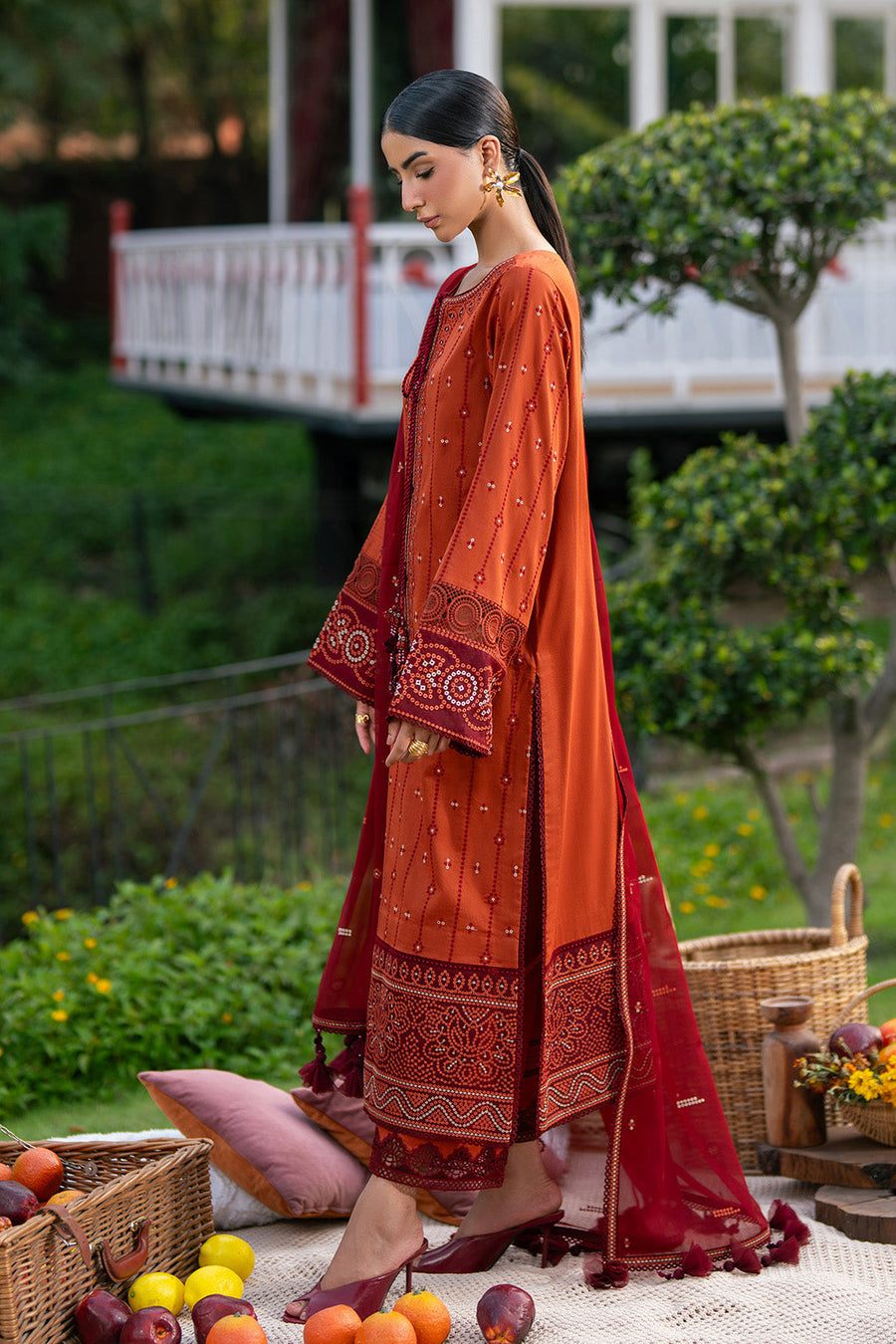 Front view of embroidered rust orange lawn suit paired with maroon dupatta and trousers