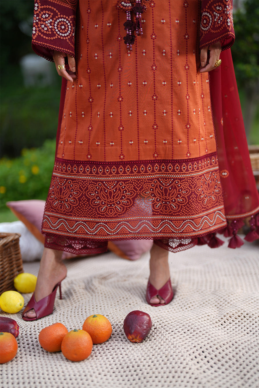 Full length view of rust lawn suit with intricate embroidery and maroon trousers with lace trim