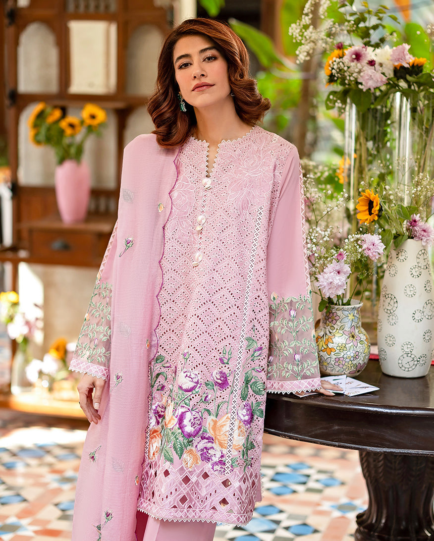Close-up of embroidered lawn shirt and trousers detailing floral cutwork and embroidery near the hem paired with a scalloped pink embroidered dupatta.