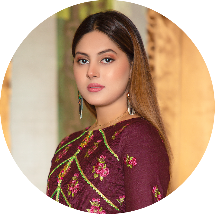 Woman wearing a maroon saree with floral embroidery against a blurred background