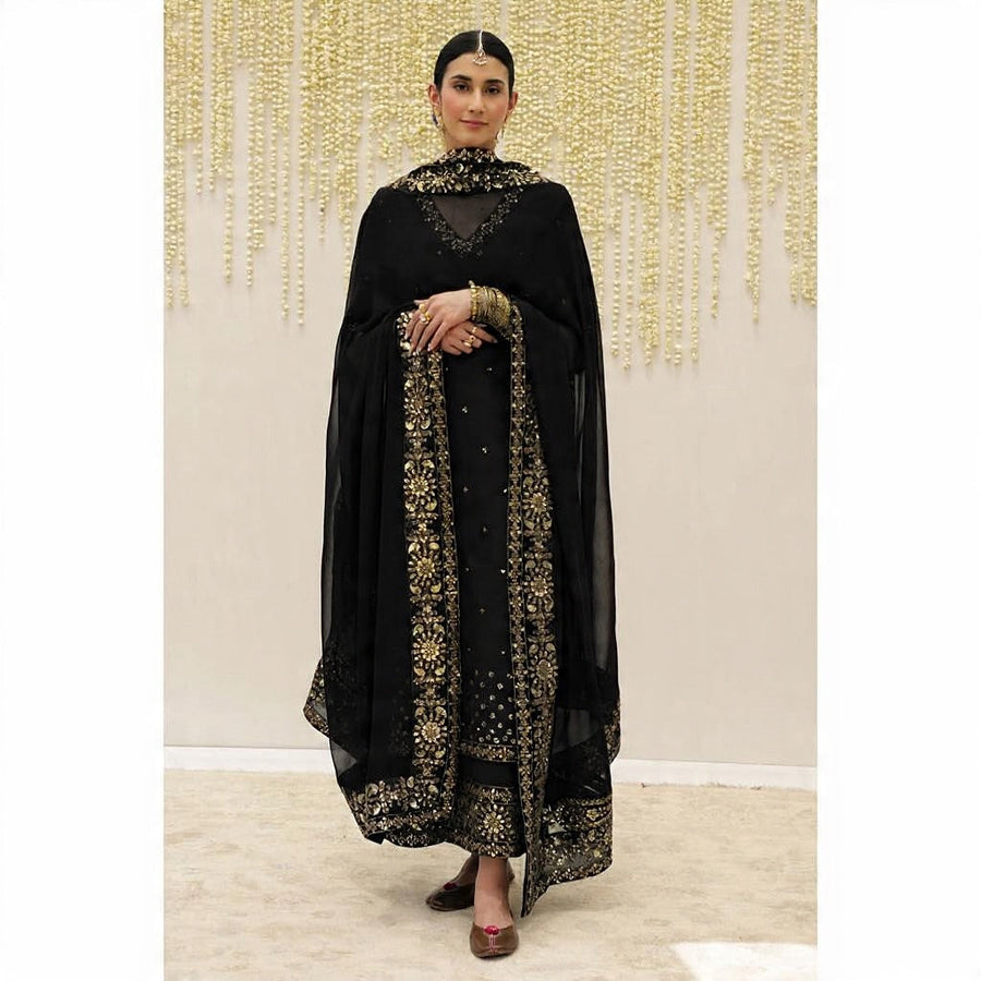 Woman wearing black full-sleeve tunic with gold embroidery paired with embroidered trousers and sheer dupatta