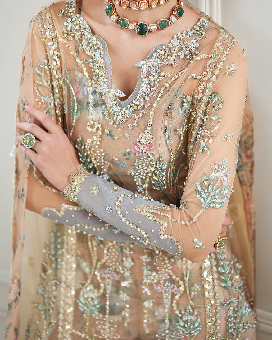 Close-up of neckline and sleeve embroidery showing intricate hand-stitched sequins and beadwork with floral motifs and coordinating jewelry