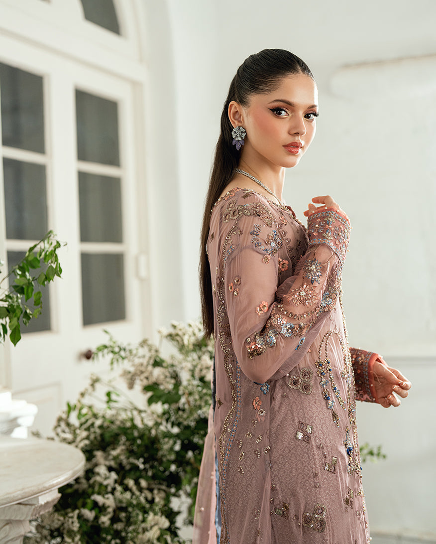 Side portrait of the model showcasing the intricate embroidery on the gown and elegant earrings complementing the outfit