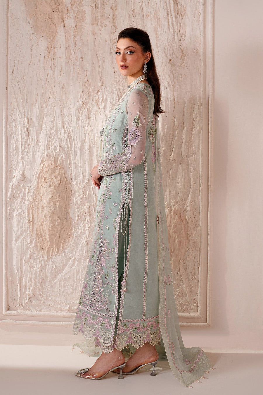 Side view of woman wearing embroidered chiffon suit with matching dupatta draped over shoulder