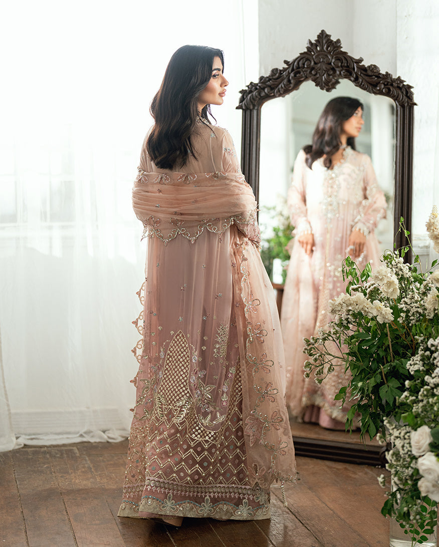Back view of woman in detailed chiffon dress with embroidered geometric motifs and pearl accents holding matching dupatta