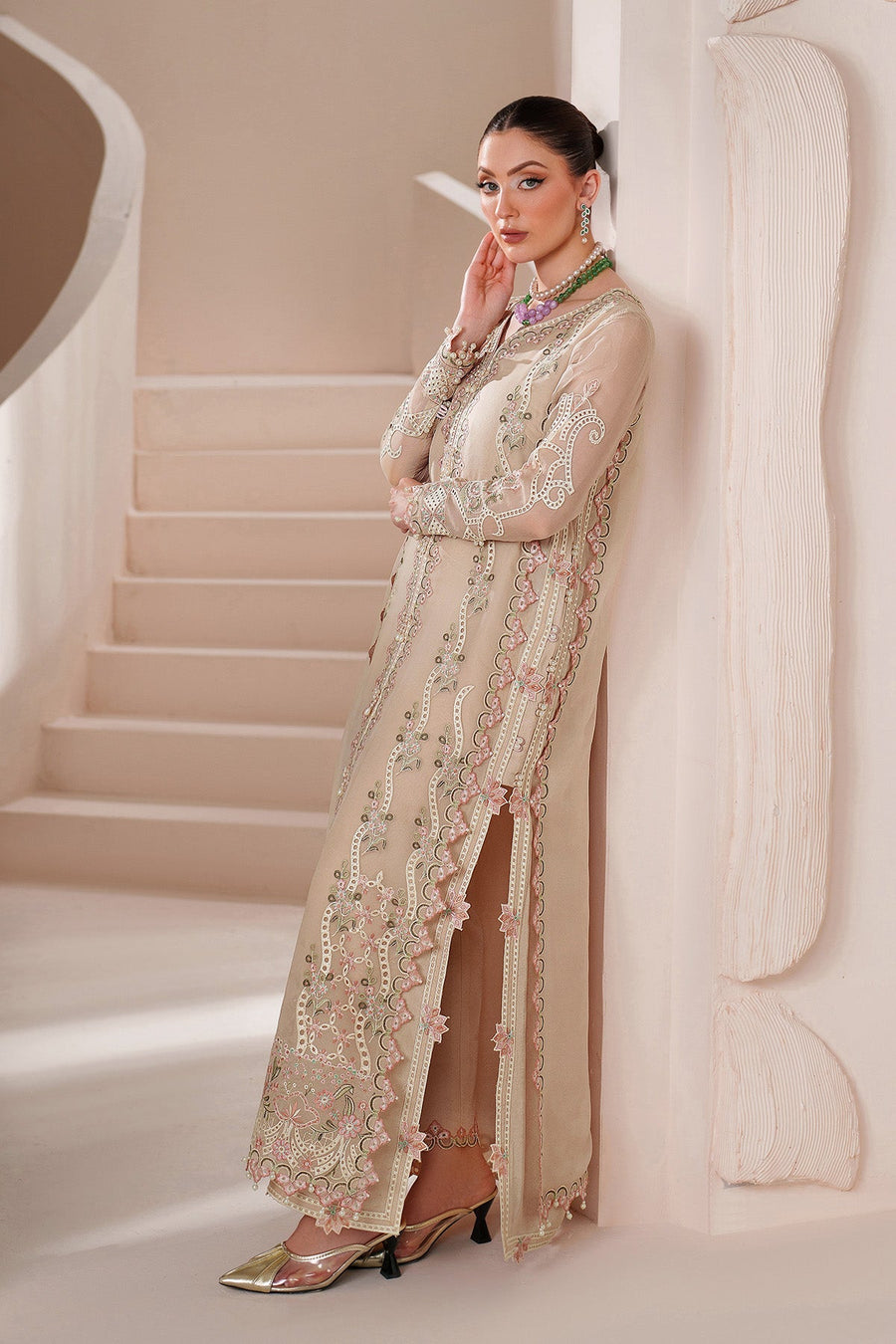 Side profile showing sheer embroidered sleeve and slit detail of chiffon dress