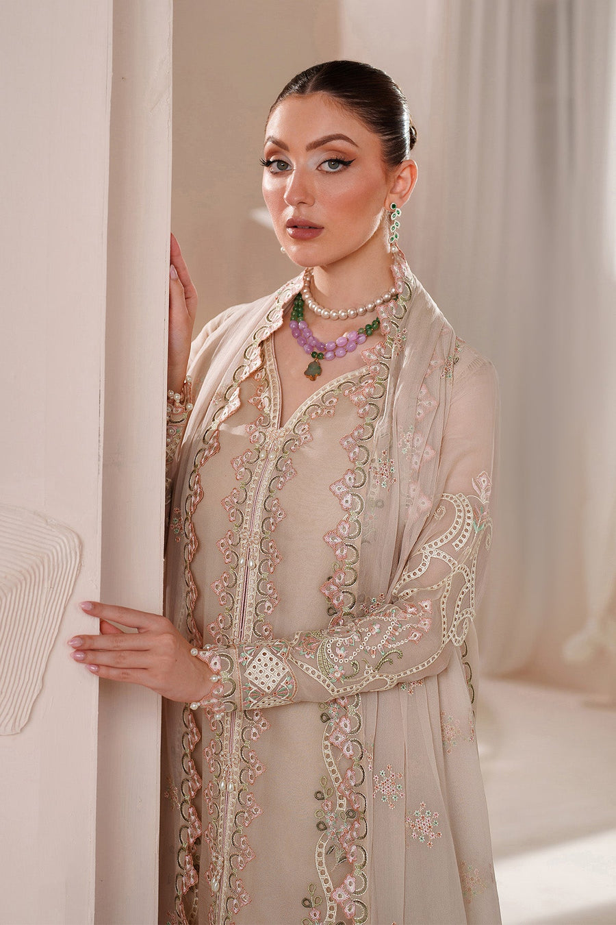 Woman donned in embroidered chiffon dress with soft makeup and hair styled in bun