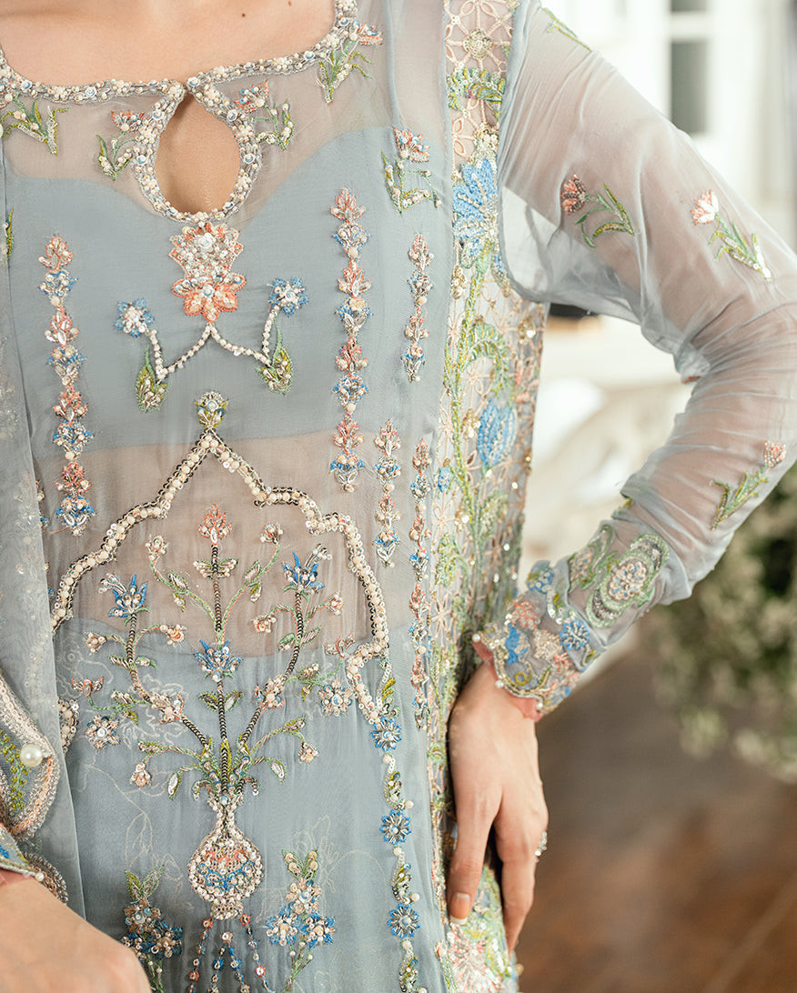 Close-up of keyhole neckline and detailed hand embroidery with sequins and delicate floral patterns on sleeves and chest