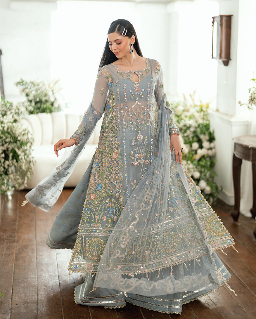 Woman twirling in embellished chiffon dress showcasing embroidered front and flowing dupatta