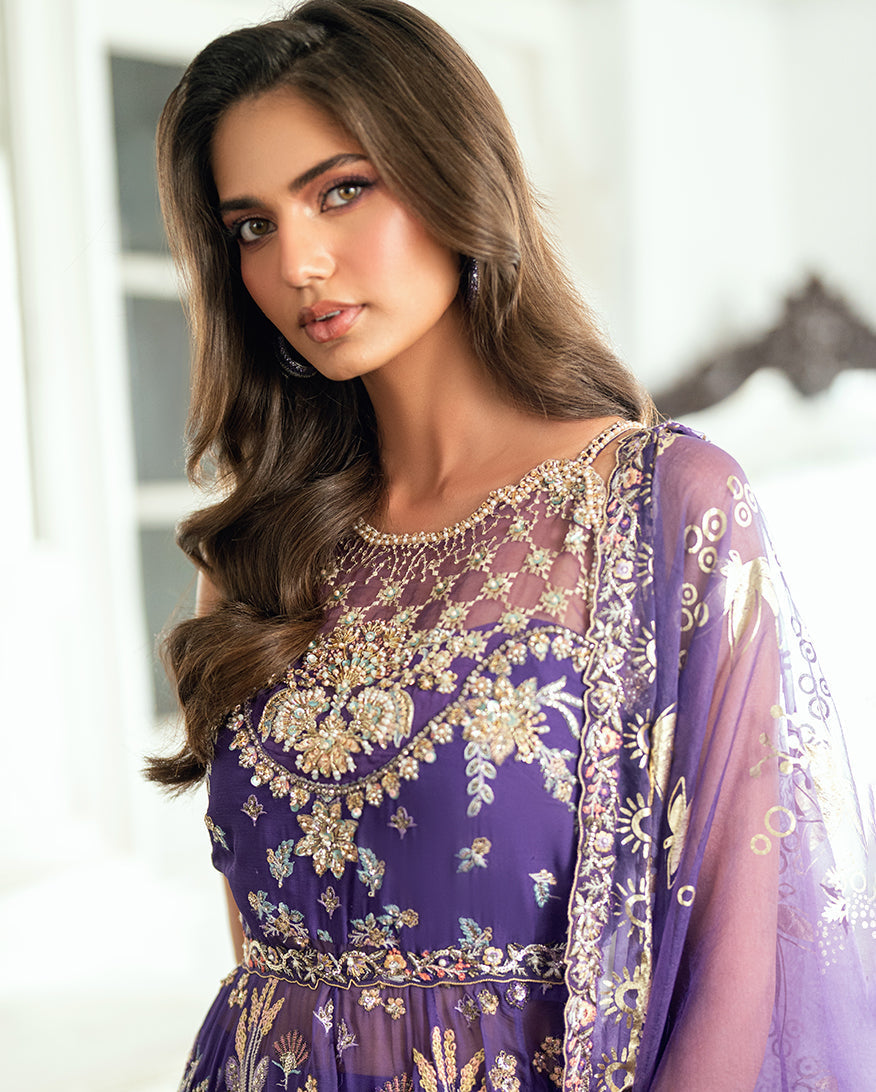Close-up of a woman’s upper body in purple gown highlighting delicate beaded neckline embellishments and sheer embroidered dupatta on shoulder