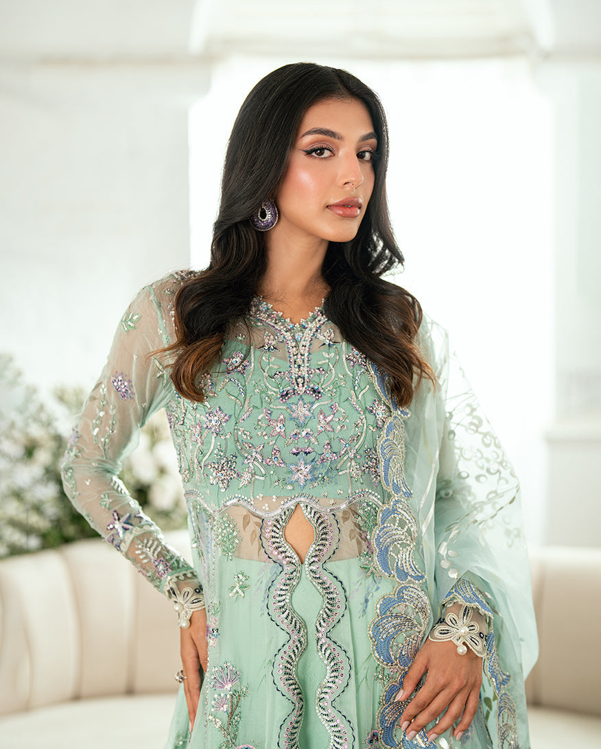 Close-up of woman’s upper torso highlighting detailed embroidery and sequin work on neckline and sleeves