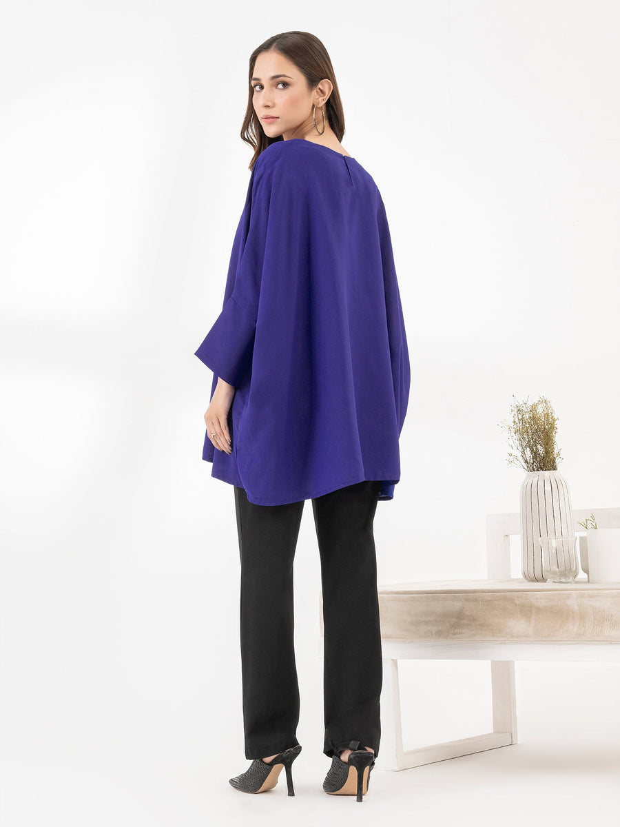 Back view of woman wearing royal blue embroidered loose fit top showing the back silhouette