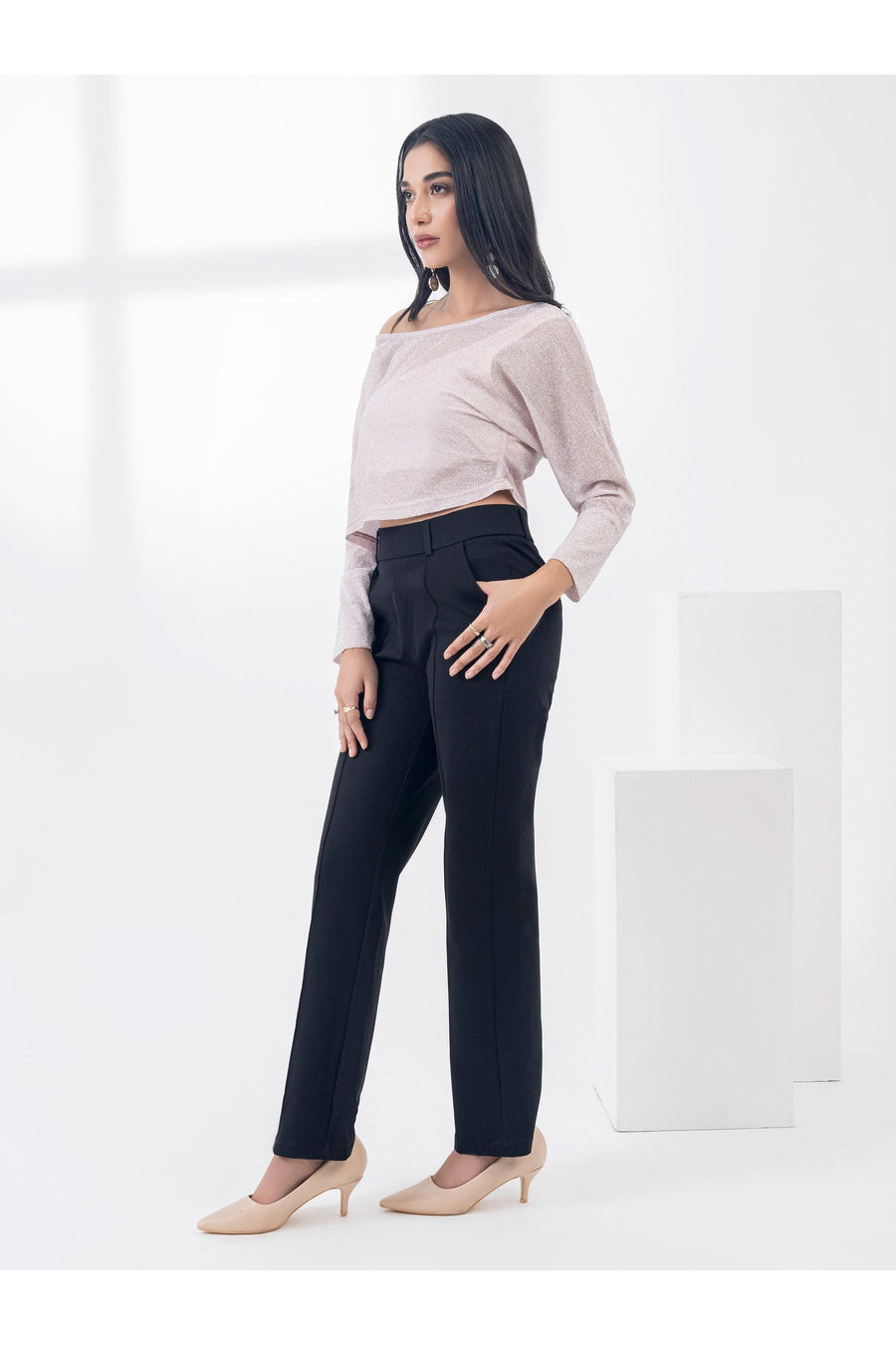 Model in dyed jersey top and black pants, standing in profile with hand in pocket