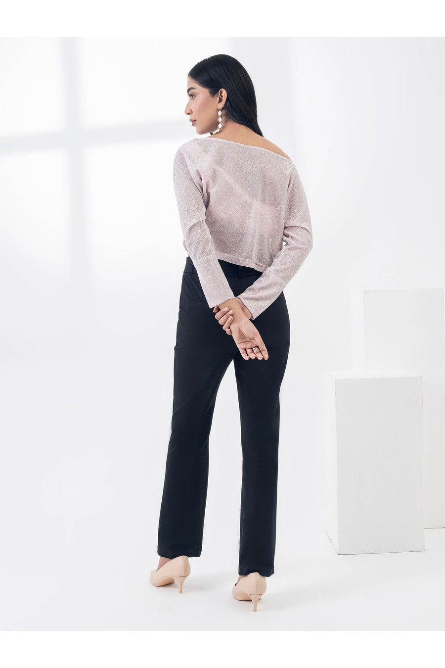 Model showing back view of light pink dyed jersey top with arms crossed behind