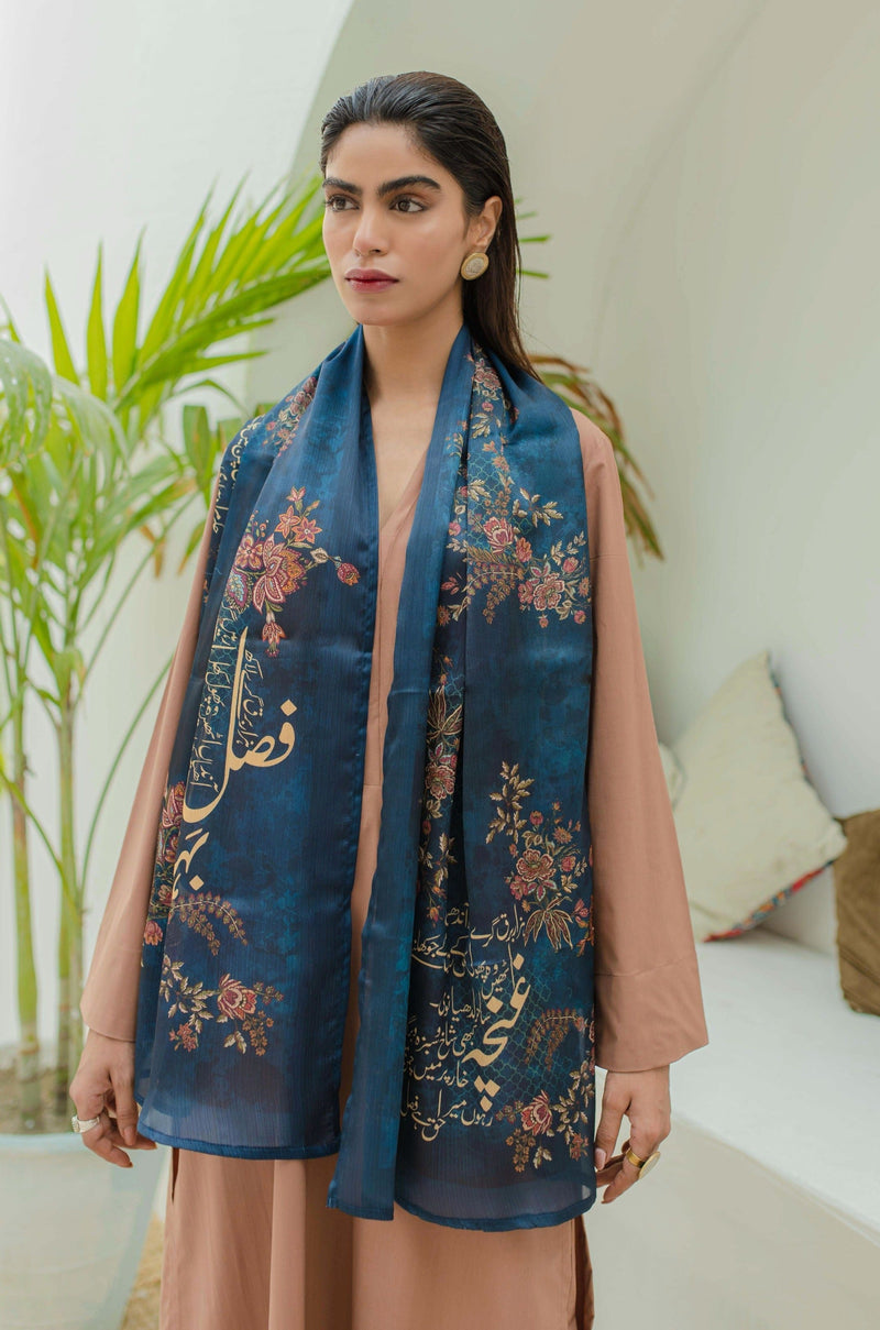 Woman wearing a luxurious midnight blue scarf with detailed floral embroidery and Urdu calligraphy, paired with a neutral-toned outfit.