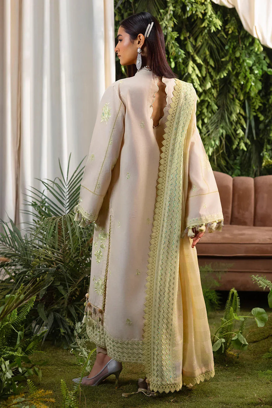 Back view of pastel cream embroidered lawn suit with scalloped neckline and tasseled borders, chiffon dupatta visible over shoulder