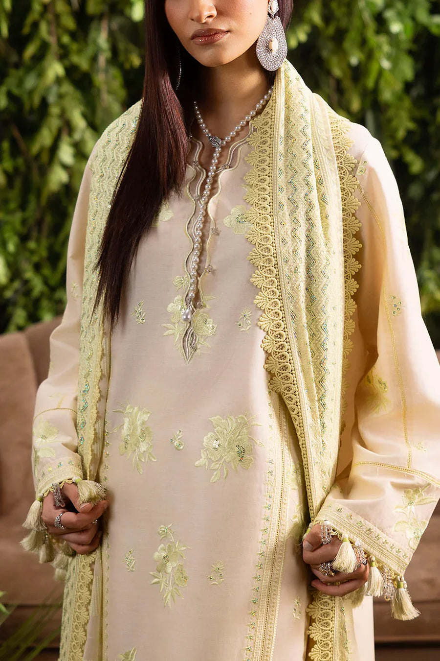 Close-up of embroidered floral details and tasseled ends on pastel cream lawn suit and chiffon dupatta with lace edging