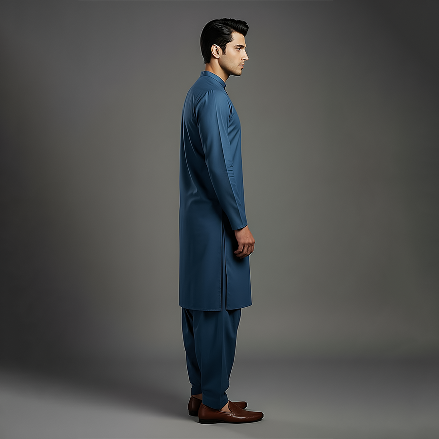 Side view close-up of a man showing the slim fit sleeves and classic style of the deep blue kurta with matching shalwar pants