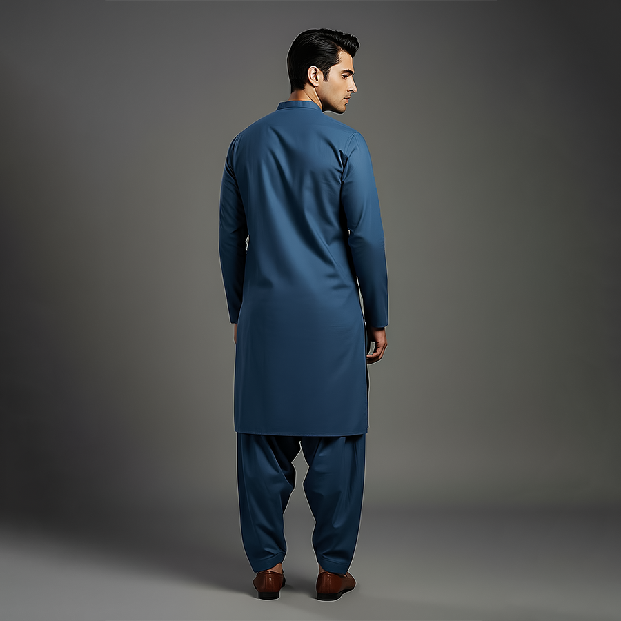 Back angle view displaying the clean lines and elegant silhouette of a deep blue kurta-shalwar outfit worn with formal brown shoes