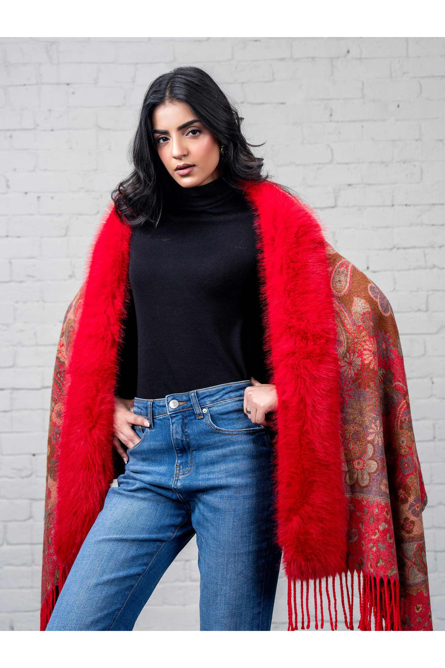Woman posing confidently in the cape with hands slightly inside, highlighting the plush faux fur trim and rich pattern details.