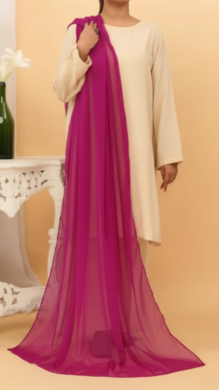 Woman wearing an elegant magenta plain chiffon dupatta draped over a beige outfit in a soft indoor setting