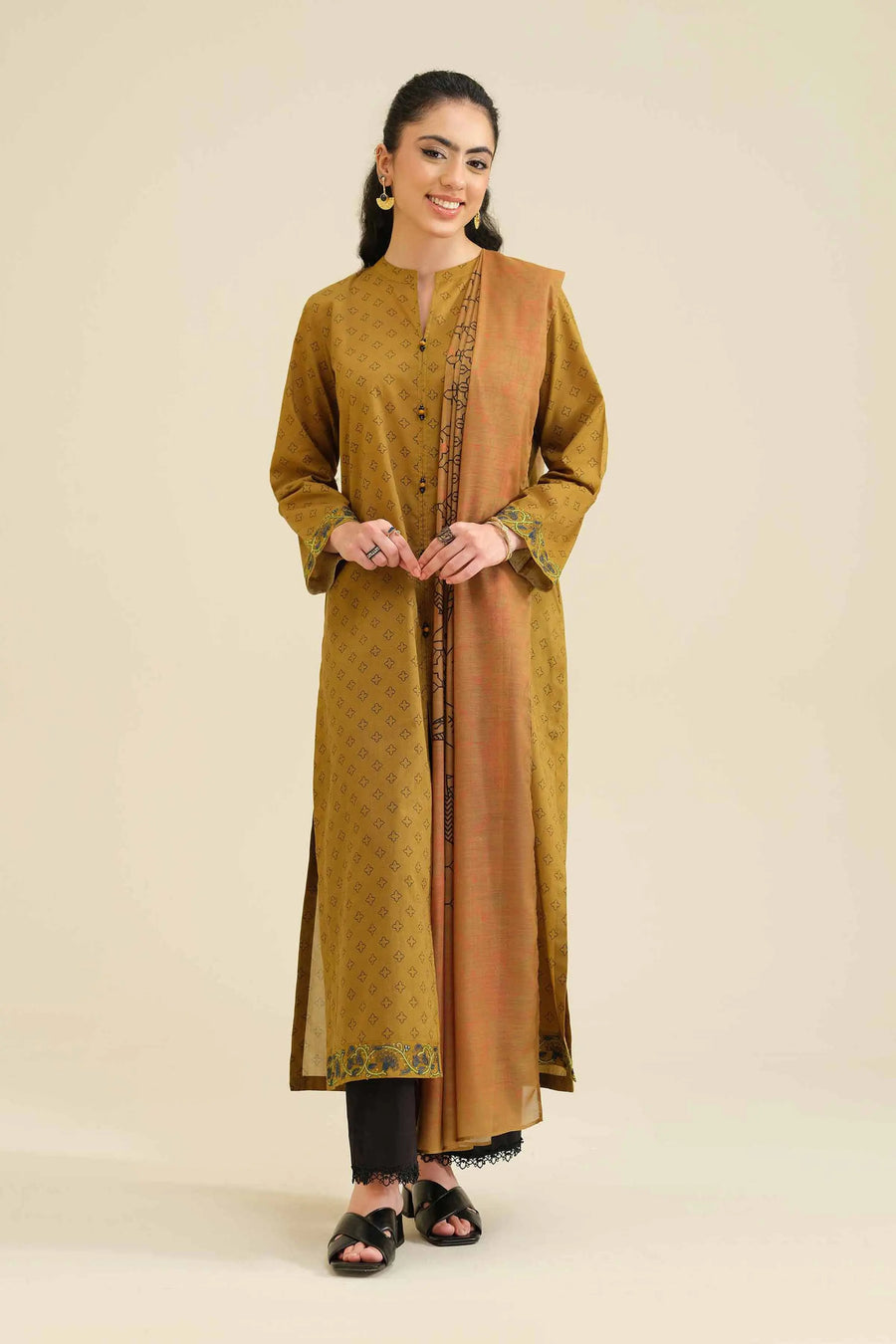 Model wearing mustard printed embroidered kurta with black trousers and matching dupatta