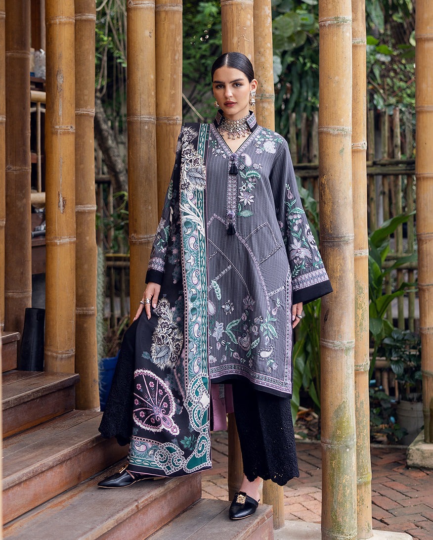 Woman wearing embroidered grey and black Karandi tunic with floral designs, paired with black embroidered trousers and matching printed shawl