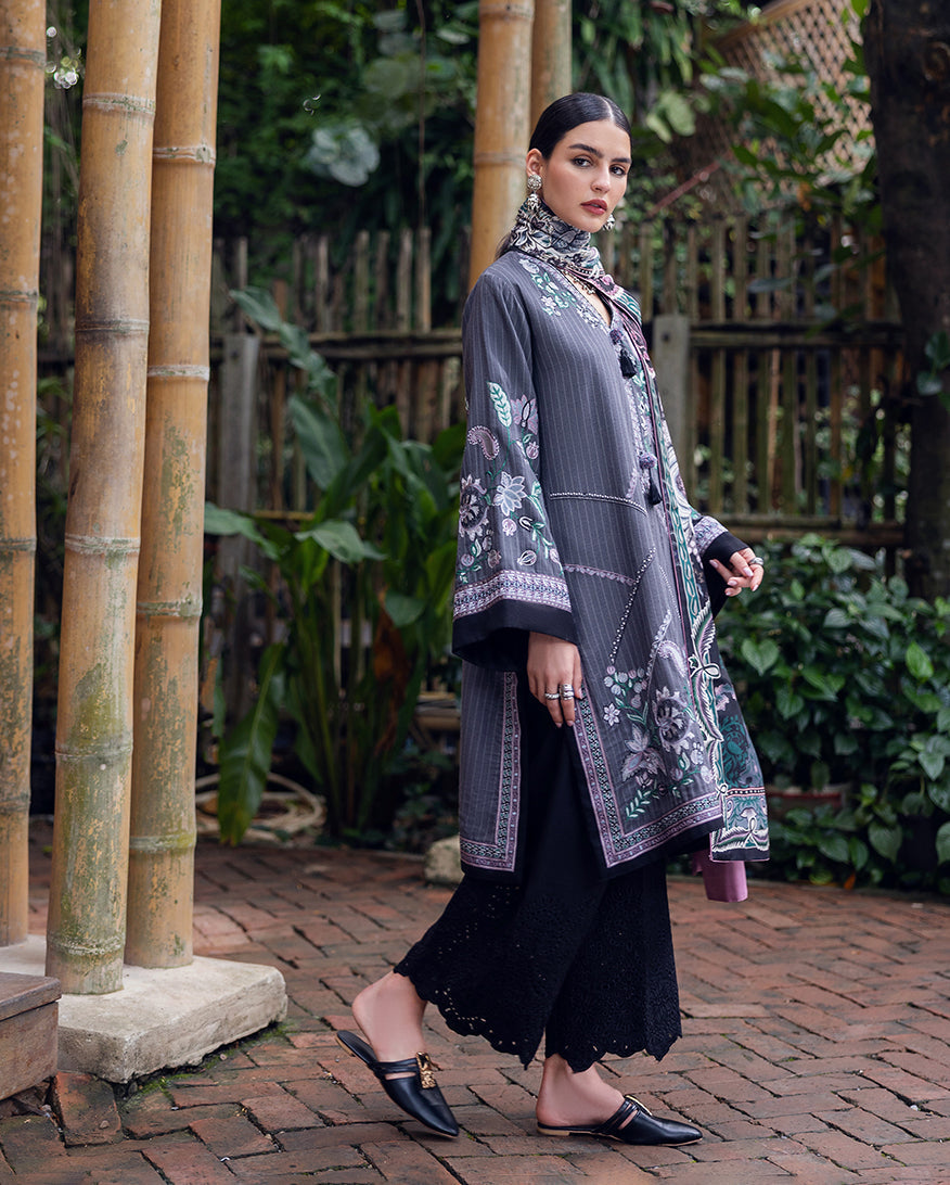 Side view of woman in floral embroidered Karandi tunic showing sleeve and trouser details, wearing black mule shoes