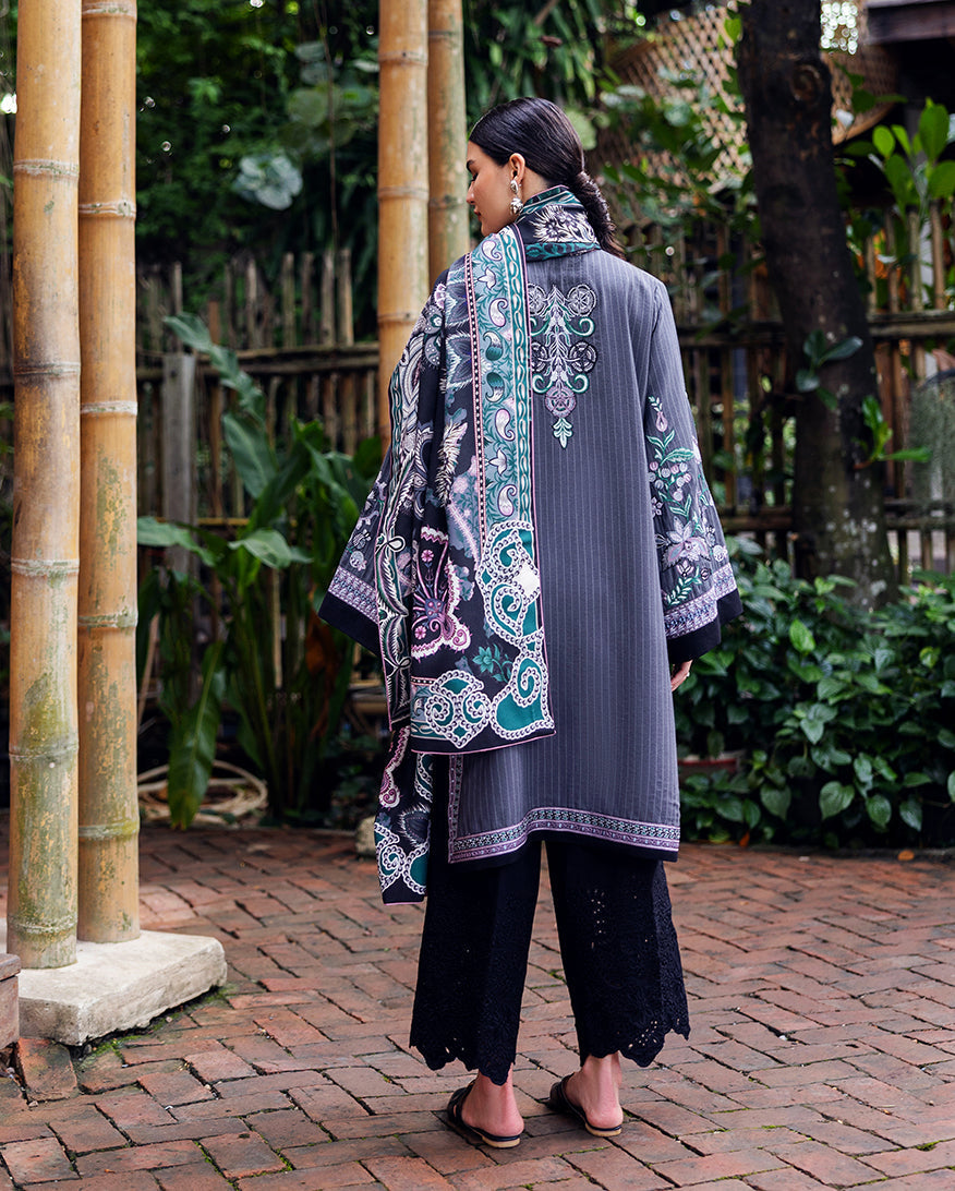 Back view of embroidered Karandi outfit with printed shawl draped over shoulder, highlighting floral and geometric patterns