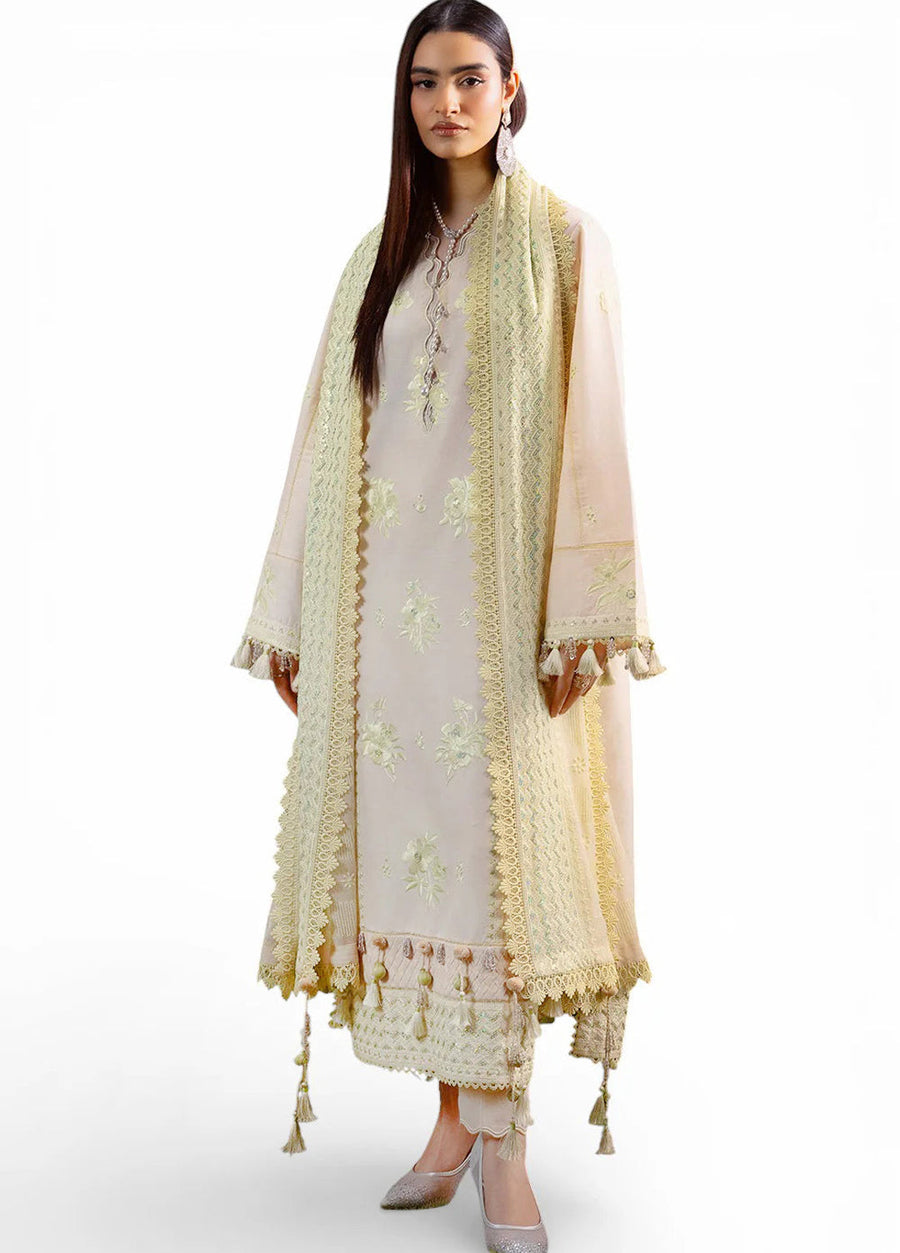 Front view of woman wearing pastel cream embroidered lawn suit with tassel details and chiffon dupatta draped over shoulders