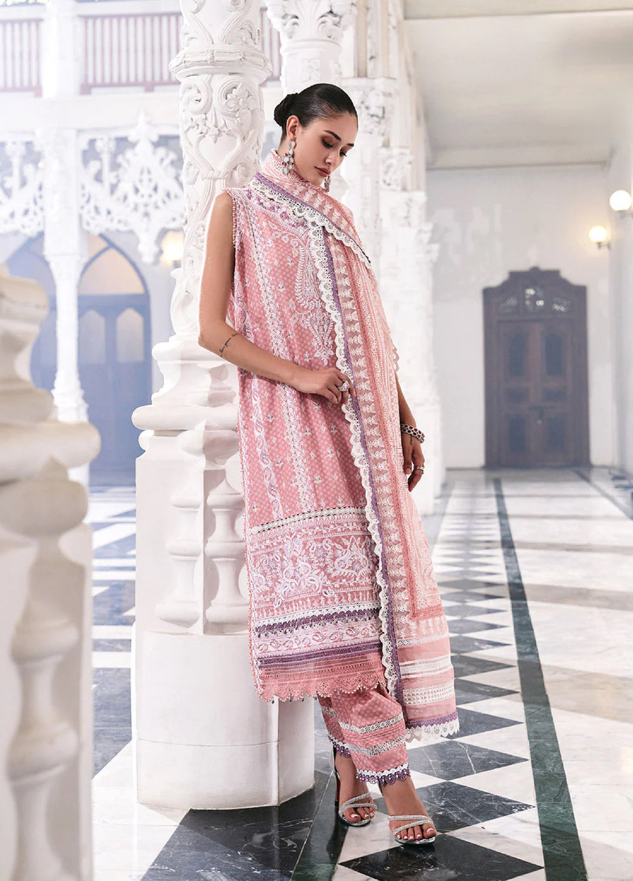 Woman in embroidered pastel pink lawn suit leaning on an ornate white column in a marble hallway