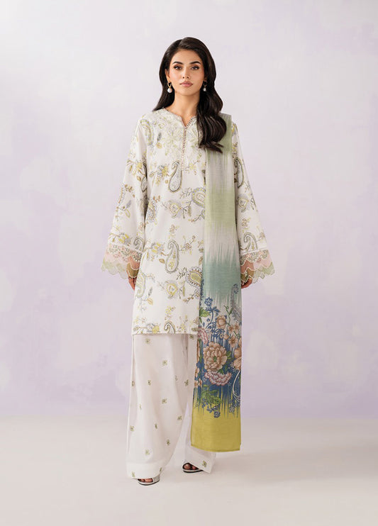 Woman wearing an elegant cream-colored embroidered lawn suit with botanical motifs, paired with loose trousers and a green and floral printed dupatta.