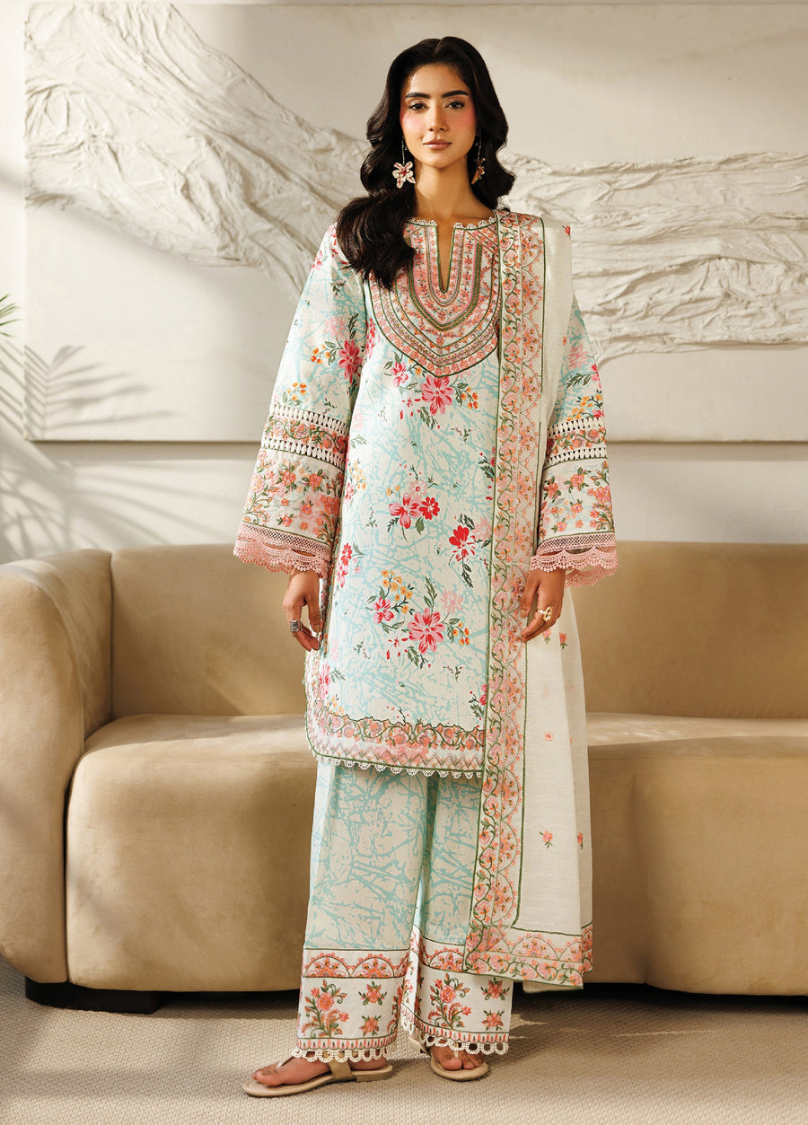 Front view of a woman wearing a pastel blue floral lawn suit with pink embroidery on the neckline and lace-trimmed sleeves, paired with matching trousers and an embroidered dupatta.