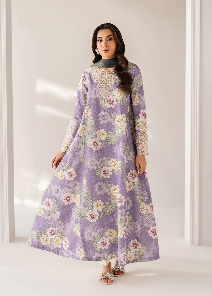 Woman wearing a floor-length lavender floral dress featuring intricate lace embroidery on the neckline and sleeves, paired with a matching scarf and silver floral sandals.