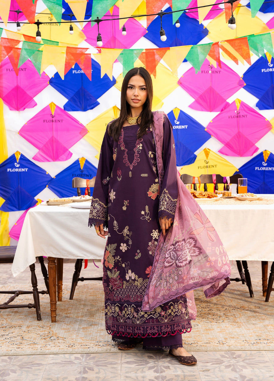 Woman in deep purple embroidered lawn suit standing in front of colorful kites and festive table setting, holding a floral printed mauve chiffon dupatta.