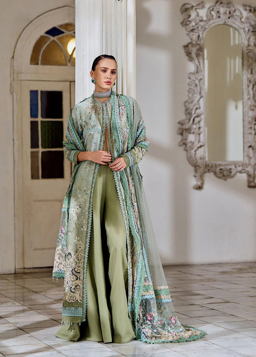 Woman wearing a sage green embroidered lawn suit with wide-leg trousers and an intricate sheer embroidered dupatta in a classic indoor setting