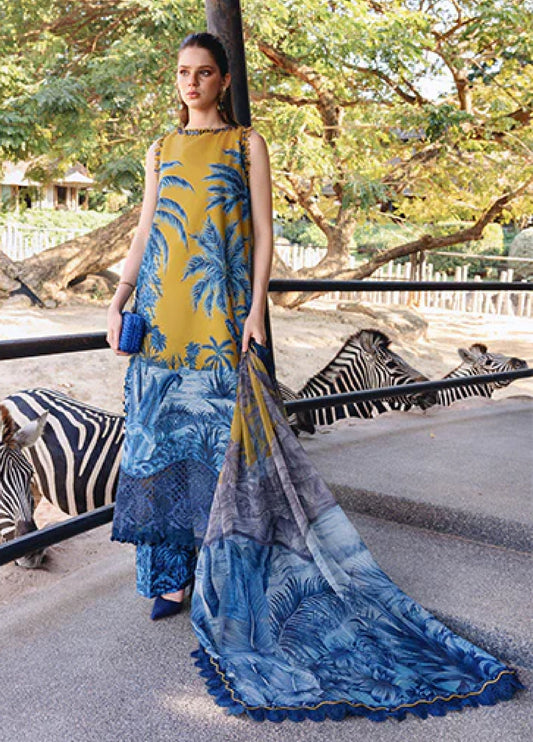 Woman wearing a sleeveless mustard yellow and blue printed lawn 3-piece suit standing outdoors near zebras