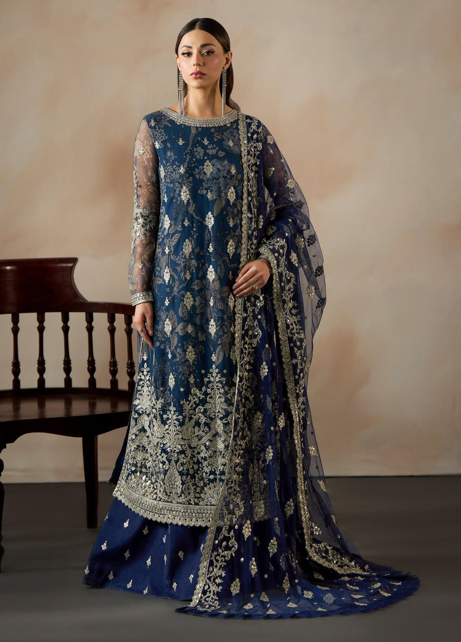 Front view of a woman wearing a navy blue net suit with silver floral embroidery and a matching embroidered dupatta