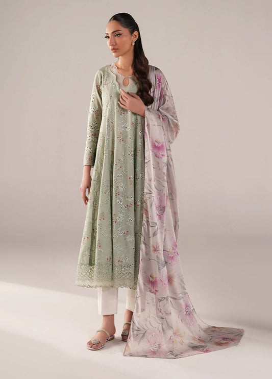 Woman wearing pastel sage green embroidered lawn frock with floral cutwork and matching floral printed chiffon dupatta, paired with white trousers