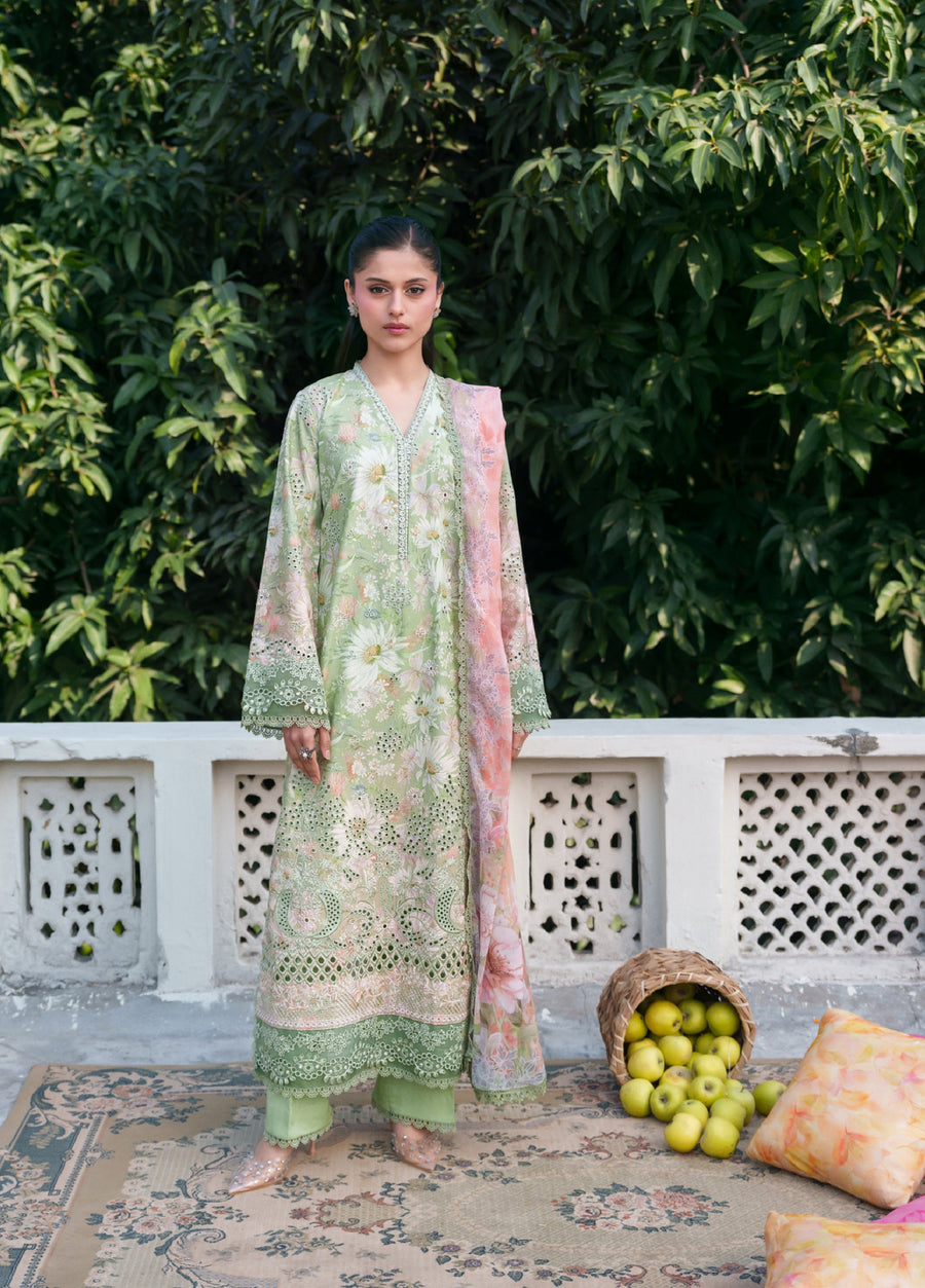 Front view of a woman wearing a pastel green floral embroidered traditional three-piece suit with a peach floral chiffon dupatta, standing outdoors