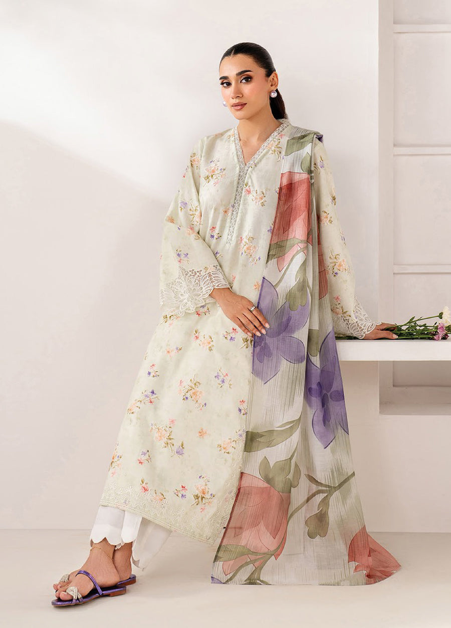 Woman posing in a cream lawn suit with delicate floral print and lace detailing, styled with white scalloped pants and a large floral dupatta draped over one shoulder.