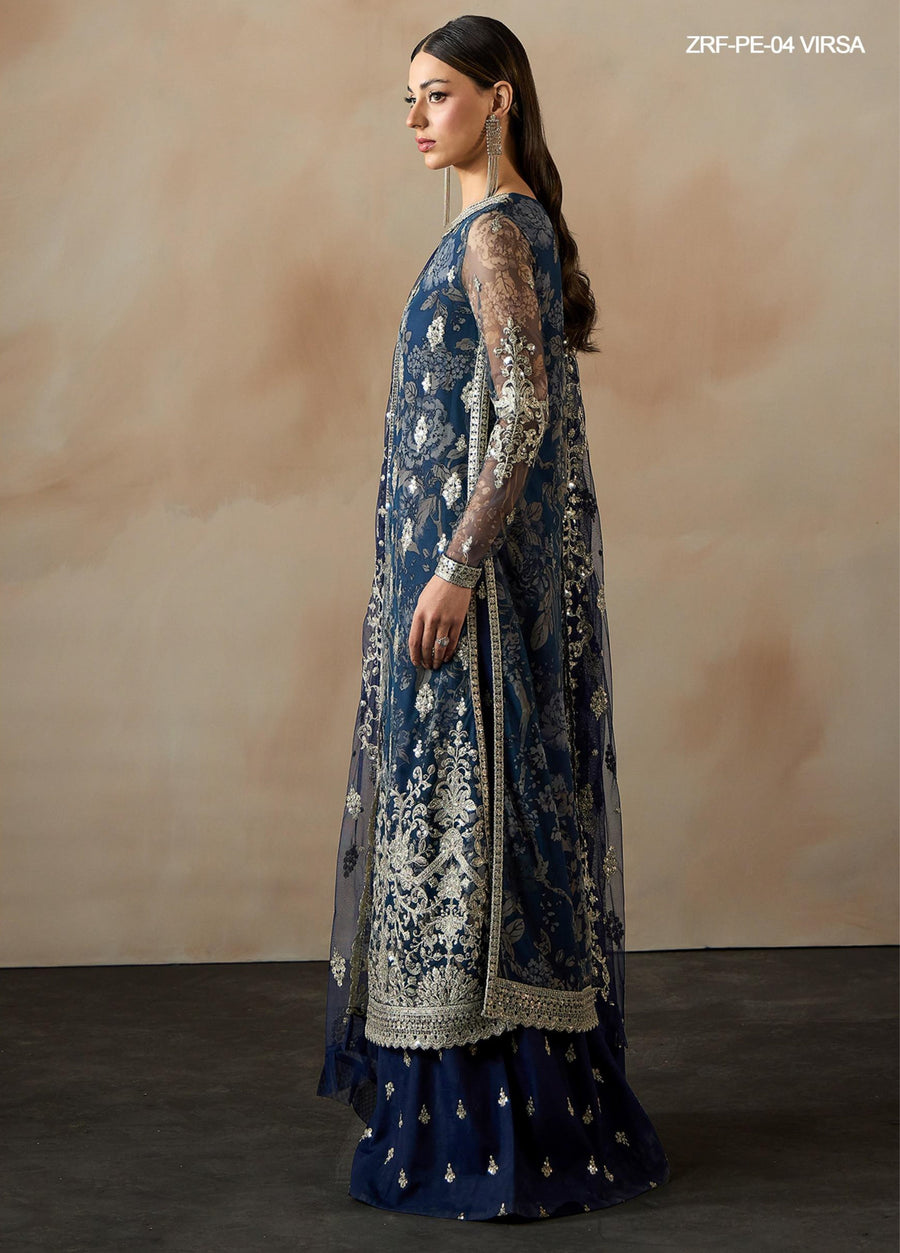 Side profile of a woman in a navy blue embroidered net suit showing sheer embroidered sleeves and detailed embroidery on the dress