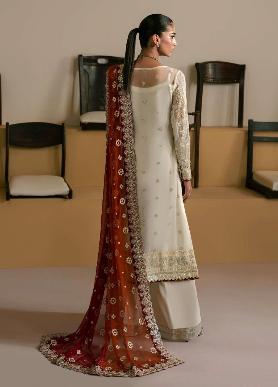 Back view of woman showcasing the delicate embroidery and mesh detail on ivory chiffon shirt with red-orange embroidered dupatta draped over shoulder