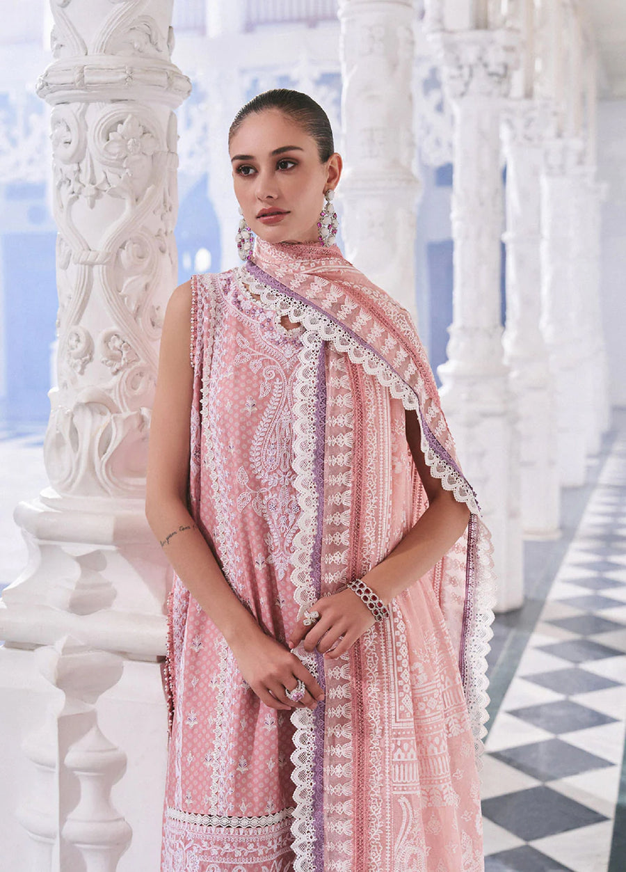 Close-up of a woman wearing an embroidered pink lawn suit with lace trimmed dupatta and large earrings