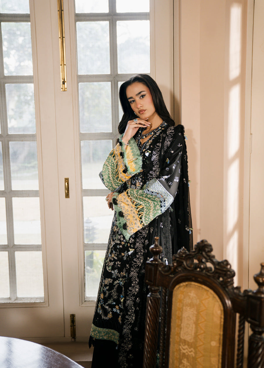 Side view of woman in black embroidered suit showing detailed sleeve embroidery and matching dupatta draped over shoulder