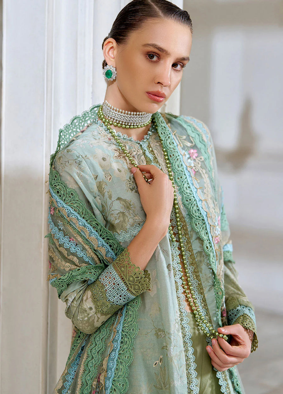 Close-up of woman showcasing detailed floral embroidery on the shirt sleeves and neckline with matching delicate lace trims and green jewelry