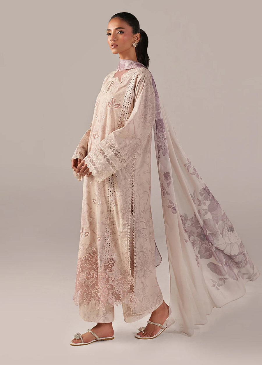Side view of a woman in beige embroidered lawn suit featuring a long flowing silk chiffon dupatta with mauve floral print