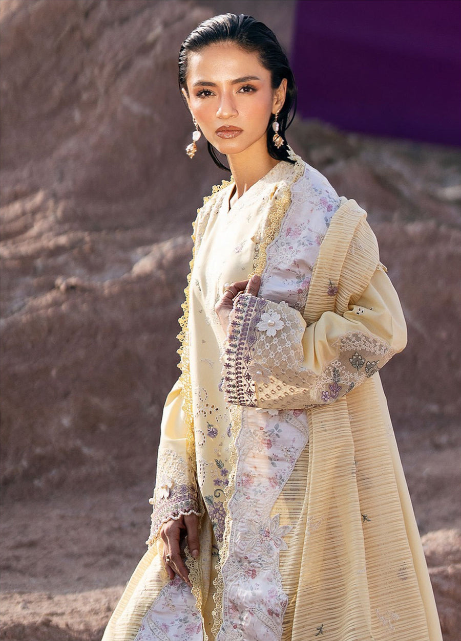 Close-up of woman wearing pastel yellow embroidered suit highlighting intricate sleeve embroidery and delicate floral dupatta
